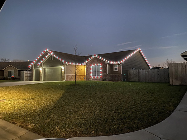 brick home with multi-colored holiday lighting